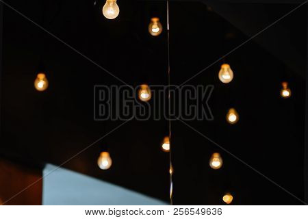 Burning Bulb Shines Weakly On The Background Blurred Yellow Lights