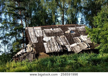 Old Building With Decaying Ruberoid Roofing Half Replaced With New One.