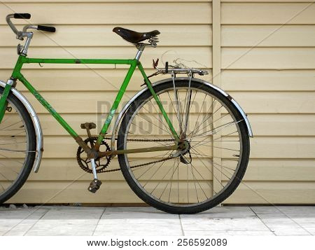 Old Bicycle With Green Frame And Rusted Metallic Parts.