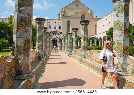 NAPLES, ITALY - AUGUST 1, 2018: Sunny cloister of the Clarisses decorated with majolica tiles from Santa Chiara Monastery in Naples, Italy. 