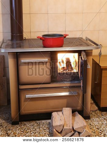 Old Wood Stove With Fire In The Kitchen Of The Chalet In The Mountains