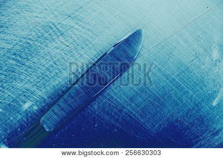 Steel Surgical Knife On The Scraped Metallic Surface.