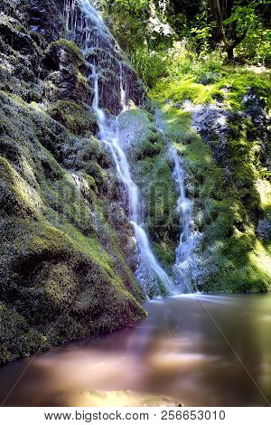 Small Mountain Waterfall On The Rocks Covered With Moss In The Forest. Processed In Nik Color Efex P