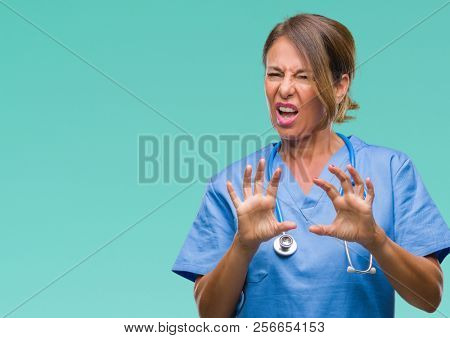 Middle age senior nurse doctor woman over isolated background disgusted expression, displeased and fearful doing disgust face because aversion reaction. With hands raised. Annoying concept.