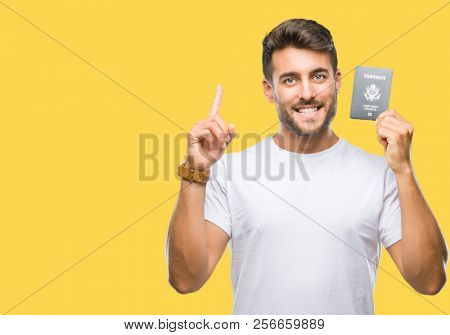 Young handsome man holding passport of united states over isolated background surprised with an idea or question pointing finger with happy face, number one