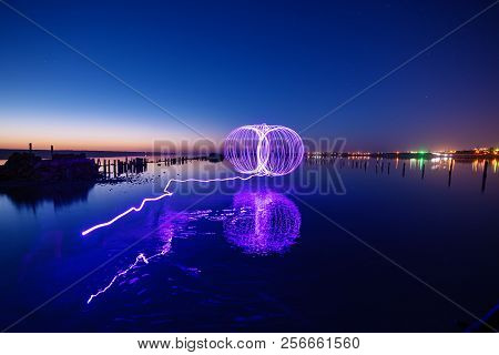 Amazing Laser Fireshow Performance In The Night Blue Sky With Reflections In The Sea Water