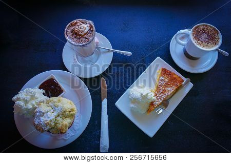 Top View Of Two Cups Of Coffee With Scone With Whipped Cream And Cake