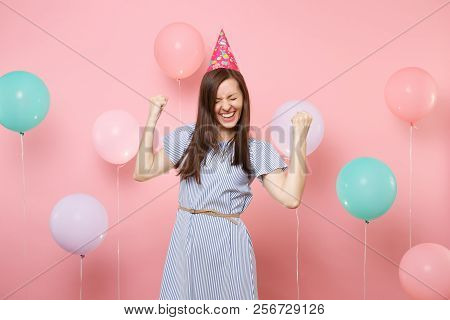 Portrait Of Overjoyed Young Woman With Closed Eyes In Birthday Hat Blue Dress Doing Winner Gesture S