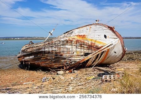 Old Wooden Fishing Boat Ruin On The Riverbank With Views Across The River Guadiana Towards Castro Ma
