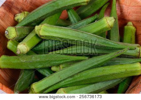 Whole Raw Okra In A Wooden Bowl.