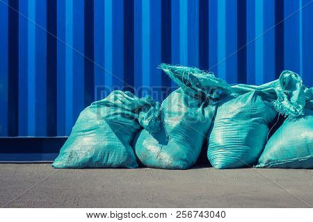 Blue Bags With Building Trash Arraged Next To Blue Wall. Disposal Of Constration Rubbish.