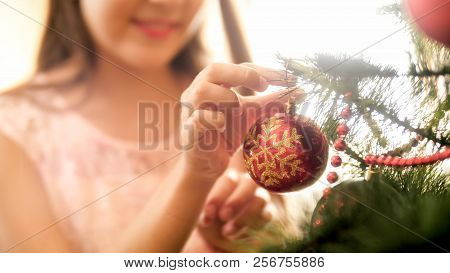 Toned Closeup Photo Of Beautiful Young Woman Decorating Christmas Tree At Living Room