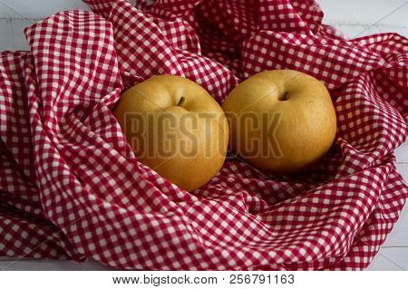 Two Chinese Pears Were Wrap By Table Cloth,on Timber Board