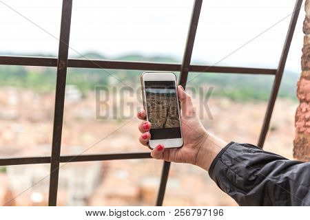 Tourist Hand Holding Smart Phone Taking Picture Of Bologna Italy