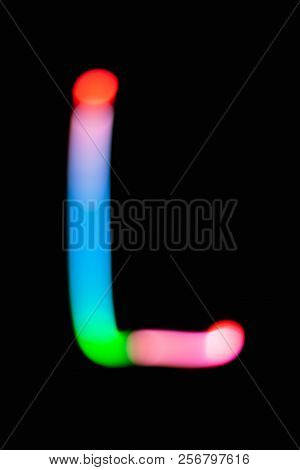 Letter L. Glowing Letters On Dark Background. Abstract Light Painting At Night. Creative Artistic Co