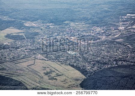 desaturated airview landscape with town and forest