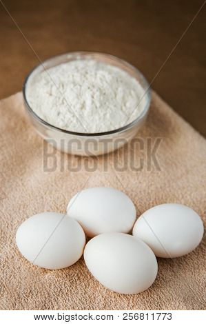 White Chicken Eggs And Plate With Flour On Brown Towel