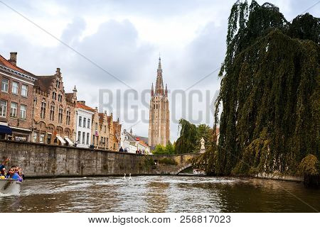 Bruges, Belgium-august 15, 2015- The Church Of Our Lady And The Medieval Houses At The Canal In Brug