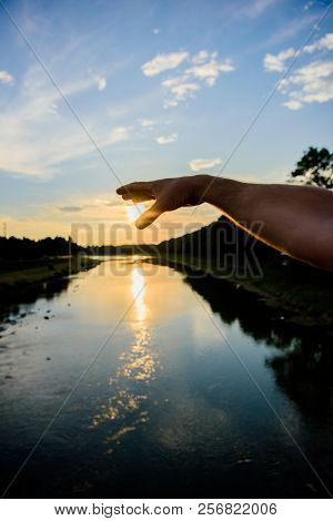 Catch Last Sunbeam. Male Hand Pointing At Sun In Blue Sky At Evening Time Admire Landscape. River Su