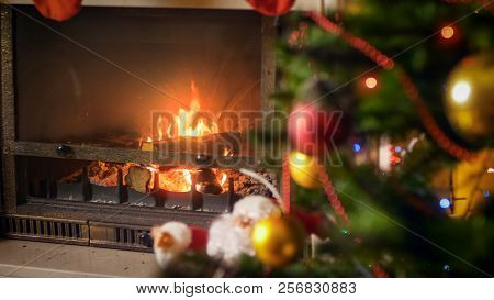 Closeup Image Of Burning Fireplace In Living Room At House With Decroated Christmas Tree