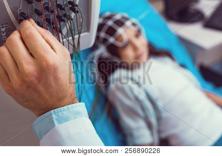 Close Up Of Male Doctor Adjusting Electroencephalograph