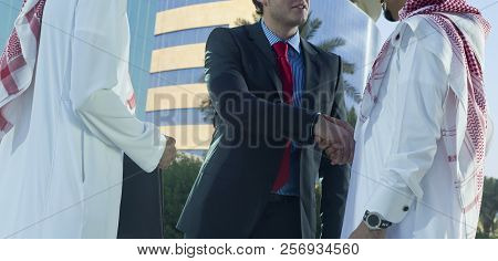 Middle Eastern And Caucasian Businessmen Shaking Hands Outdoor