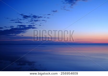 Beautiful Sunset Over Sea With Reflection In Water. Majestic Clouds In The Sky. Deep Blue Sea. The S