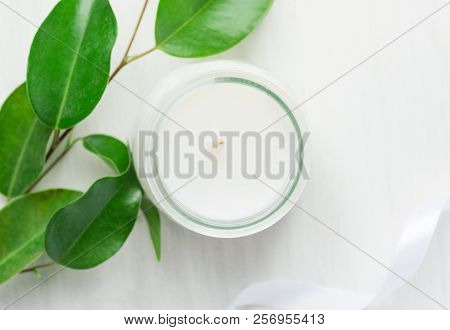 White Candle In Glass Jar Fresh Tree Branches With Tender Green Leaves Silk Ribbon On Wood Backgroun