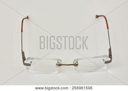 Pair of rimless eye-glasses on white background.