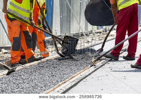 Workers Construct Asphalt Road And Railroad Lines