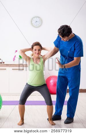 Pregnant woman doing physical exercies with instructor