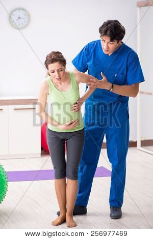 Pregnant woman doing physical exercies with instructor