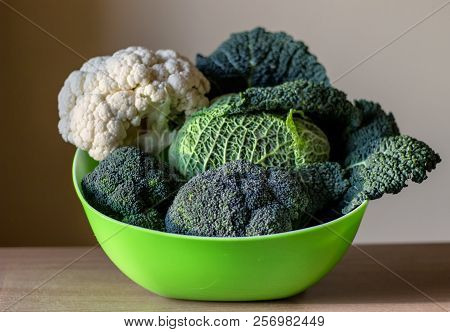 Organic Vegetables - Savoy Cabbage, Broccoli, White Cabbage In A Green Bowl On The Wooden Table On W