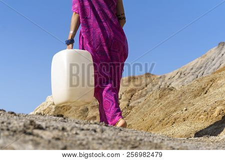 A Girl In Ethnic Clothing Goes For Water With A Plastic Jerrican