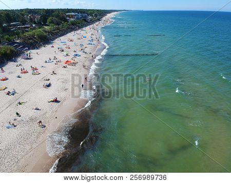 MIELNO, POLAND - 02 SEPTEMBER 2018 - Aerial view on sunny beach with tourists at baltic sea on Mielno city