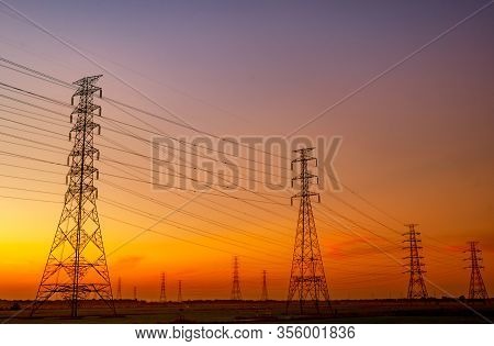 High Voltage Electric Pylon And Electrical Wire With Sunset Sky. Electricity Poles. Power And Energy