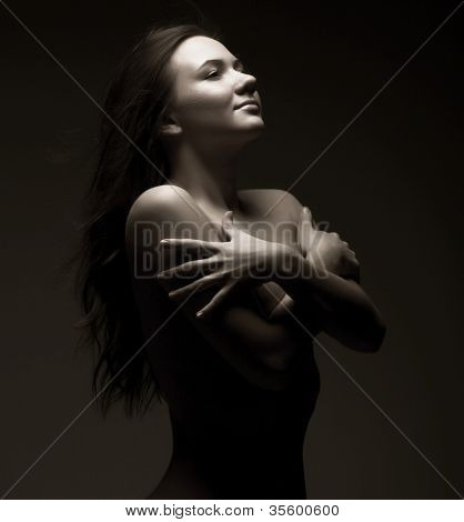 สตูดิโอภาพเหมือนของหญิงสาว topless ใน semidarkness