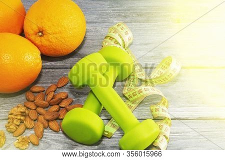 Lots Of Oranges, Dumbbells, Measuring Tape On A Wooden Textured Background. Fitness, Sports Nutritio