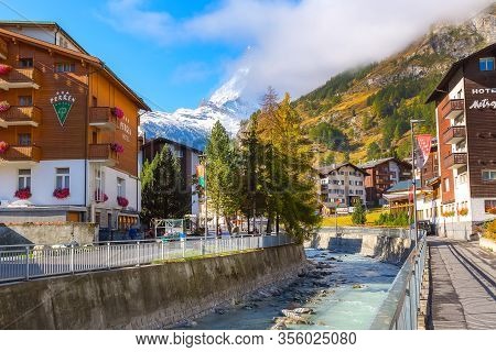 Zermatt, Switzerland - October 7, 2019: Town Street View In Famous Swiss Alps Ski Resort, River, Mat