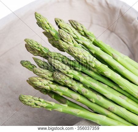 Bunches of asparagus tied on a burlap background.