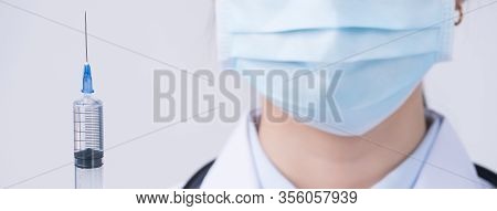 Doctor Holding Syringe With Face Mask, Concept Of Young Female Physican Injects Coronavirus, Covid-1