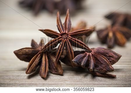 Star Anise With And Without Seeds, Closed, On A Light Wooden Surface. Spice For The Recipe. Beautifu
