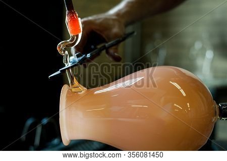 A Closeup Selective Focus Shot Of A Glassmith Making A Blown Lantern In A Studio, Using Cutters To S