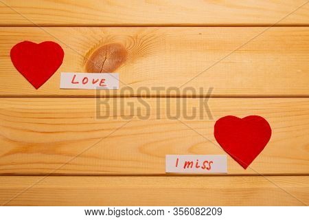 Light Wooden Background.two Hearts With The Inscription About Love.