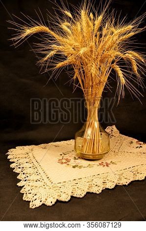Bright Sheaf Of Ripe Wheat In A Glass Vase On A Linen Napkin