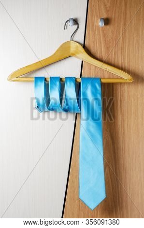 A Mans Blue Tie Hangs On The Door Of The Chiffonier. The Concept Of A Successful Mans Style.