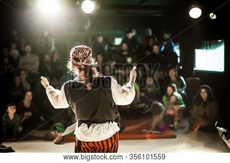 A Performing Arts Entertainer Is Seen From The Back In Selective Focus, Dressed As A Pirate On Stage