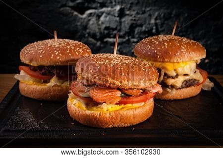 Menu Of Different Burgers On One Board. Side View Of A Fish Burger, Hamburger And Cheese Burger, Aga