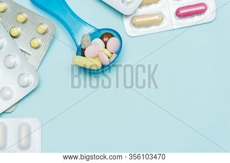 Medicine Pills On On Blue Backdrop. Different Color Pills Of Drugs And Medicines. Copy Space