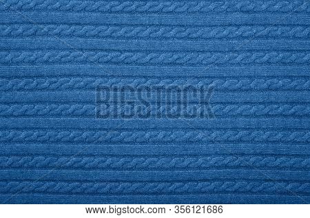 Close Up Background Texture Of Blue Cable Knitted Wool Jersey Fabric Sweater With Row Braid Pattern